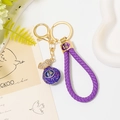 Detailed macro view of purple woven cord keychain with a blue rhinestone lucky bag pendant - Purple Lucky Bag with Purple Leather Rope