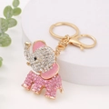 Charming gold elephant keychain with sparkling pink and white rhinestones on display - Pink