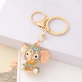 Golden elephant keychain with colorful rhinestones on a white geometric platform - Colorful Rhinestone Pink Ear Style (Style 3)