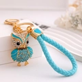 Porte-clés chouette doré avec strass bleus brillants et sangle tressée bleue - Bleu avec Cordon en Cuir