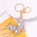 Close-up of golden butterfly keychain with inlaid sparkling crystals and lobster clasp - Keychain / White