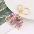 Dettaglio del portachiavi a elefante con strass viola su un piatto di ceramica bianca - Viola