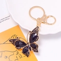Close-up of golden butterfly keychain featuring intricate black rhinestones and crystals - Keychain / Black