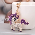 Macro detail of unicorn keychain with sparkling white rhinestones and purple glitter oil - Purple