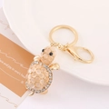 Dettaglio del portachiavi a tartaruga dorata con pietre opali e strass scintillanti - Colore 3