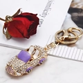 Portachiavi auto sportiva dorata con strass e smalto viola su sfondo floreale - Viola