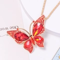 Detail of red rhinestone butterfly pendant with golden alloy frame and intricate crystals - Necklace / Red