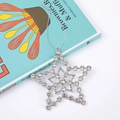 Detail of a sparkling silver star ornament with embedded rhinestones and hanging cord - Pentagram