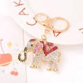Dettaglio di un portachiavi a elefante dorato con strass rosa e sella in smalto rosso lucido - Smalto Rosa (5189025458175)