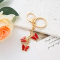 Golden butterfly keychain with three red enamel pendants and sparkling rhinestones - Red
