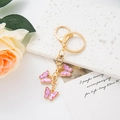 Detail of three pink enamel butterfly charms with gold keychain and lobster clasp - Light Purple