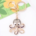 Detail van inktvis sleutelhanger met strass, goudkleurige legering en paars emaille - Grijs