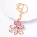 Detailweergave van de octopus sleutelhanger met roze strass en email op goud metaal - Roze
