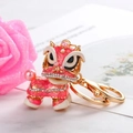 Detail van roze dansende leeuw sleutelhanger met witte strass en emaille coating - Roze