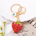 Detailansicht eines roten Erdbeer-Schlüsselanhängers mit Strass und goldenem Karabinerhaken - Erdbeere