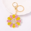 Detalle de un llavero de girasol con pedrería rosa y amarilla y cierre dorado - Rosa Amarillo Sonrisa
