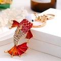 Détail du porte-clés poisson rouge avec strass rouges et émail coloré sur alliage d'or - Rouge