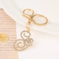 Macro shot of gold-plated S letter keychain with sparkling crystal rhinestones - Letter G(G) / Gold