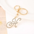Detailed close-up of golden letter K keychain with sparkling rhinestones and lobster clasp - Letter H(H) / Gold