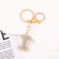 Detail of crystal letter I keychain with gold plating and rhinestones on white base - Letter I