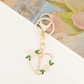 Detail of golden heart keychain with letter I, inlaid rhinestones and pink cherry blossoms - Letter I Style