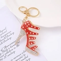 Detailed close-up of a sparkling red stiletto high heel keychain with white rhinestones - Red
