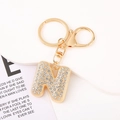 Macro shot of letter N keychain with sparkling crystals and gold lobster clasp - Letter N