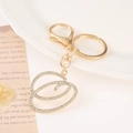 Detail of a gold-tone alphabet keychain with crystal rhinestones on vintage paper - Letter O(O) / Gold