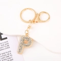 Detailed view of a gold-plated letter P keychain fully encrusted with sparkling crystals - Letter P