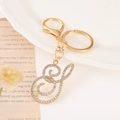Macro detail of golden rhinestone S letter keychain with lobster clasp on vintage paper - Letter S(S) / Gold