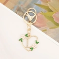 Detailed view of heart-shaped gold keychain with letter L and floral enamel details - Letter L Style