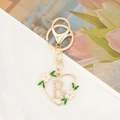 Detail view of gold heart keychain with letter B charm and pink enamel flower - Letter B Style