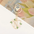 Detailed close-up of golden heart keychain with sparkling crystal letter N and enamel flowers - Letter N Style