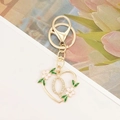 Close-up of heart-shaped letter Q keychain with pink enamel flowers and white rhinestones - Letter Q Style