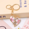 Détail du porte-clés coeur doré avec fleurs en émail rose et cristaux scintillants - Rose