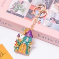 Detailopname van een kasteelsleutelhanger met kleurrijk emaille en schitterende bergkristallen - Blauwgroen en Paars Kasteel
