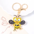 Gros plan du porte-clés abeille dorée avec strass jaunes et détails en émail noir fin - Ailes Noires (Couleur 5)