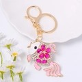 Detail of goldfish keychain with pink gemstones and white crystals on a gold base - Pink