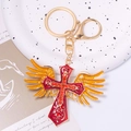 Detailed close-up of golden wing cross keychain with red enamel and sparkling rhinestones - Cross Style 4