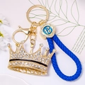 Close-up of a luxury crown keychain with blue woven leather cord and sparkling crystals - Crown With Black Leather Rope / Black
