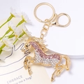 Dettaglio del portachiavi a cavallo dorato con strass scintillanti sfumati in rosa e bianco - Stile Rosa E Bianco