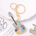 Dettaglio portachiavi a chitarra con strass blu e pietre colorate a occhio di gatto - Colore 2