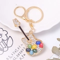Dettaglio di un portachiavi a chitarra dorata con strass colorati e design a fiori di cristallo - Stile Strass Blu Chiaro (Colore 1)