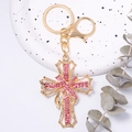 Dettaglio portachiavi a croce con strass rosa, lega dorata e chiusura a moschettone - Oro Zirconia Rosa
