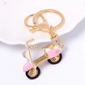 Detail eines rosa-weißen Roller-Schlüsselanhängers mit Kristallen und Gold-Finish - Einzelnes Motorrad-Stil / Rosa