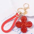 Dettaglio di un portachiavi a quadrifoglio rosso scintillante con ciondolo a cuore dorato - Quadrifoglio Rosso Con Corda Intrecciata