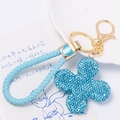 Dettaglio portachiavi quadrifoglio con strass blu, chiusura dorata e cordino in pelle - Quadrifoglio Blu Con Corda Intrecciata