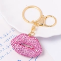 Detail of pink crystal encrusted lip keychain with golden ring on a white plate - Pink Lips (No Rope)