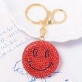 Dettaglio del portachiavi con faccina sorridente in strass rossi e chiusura dorata - Ciondolo faccina sorridente rosso