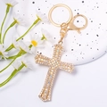 Detail of a sparkling golden cross keychain featuring brilliant white rhinestones - Cross Style 7